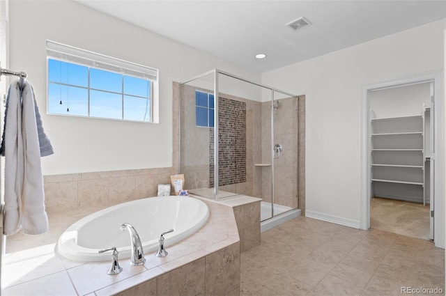 full bathroom featuring a walk in closet, a garden tub, visible vents, a shower stall, and tile patterned floors