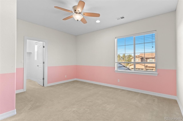 empty room featuring carpet floors, visible vents, baseboards, and a ceiling fan