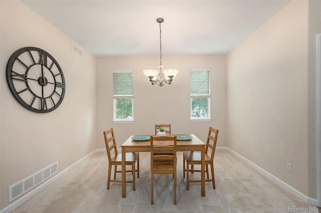 dining room with a chandelier, baseboards, and light colored carpet