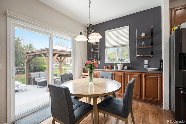 dining space featuring wood finished floors and a chandelier