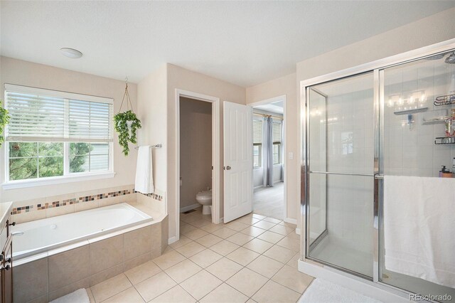 bathroom featuring healthy amount of natural light, a stall shower, tile patterned floors, and toilet