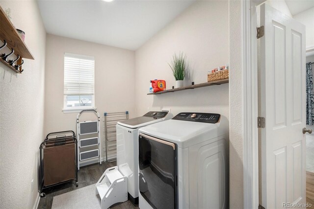 clothes washing area with separate washer and dryer, dark wood-style floors, and baseboards