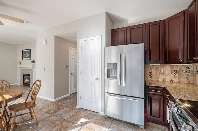 10359 Tracewood Dr, Highlands Ranch, CO 80130 - kitchen with appliances with stainless steel finishes, backsplash, ceiling fan, a glass covered fireplace, and baseboards