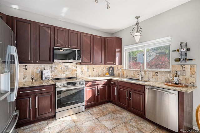 10359 Tracewood Dr, Highlands Ranch, CO 80130 - kitchen featuring appliances with stainless steel finishes, a sink, pendant lighting, backsplash, and light stone countertops
