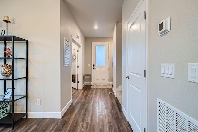 hallway featuring dark wood-style floors and baseboards