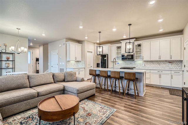 living area featuring recessed lighting, wood finished floors, and a chandelier