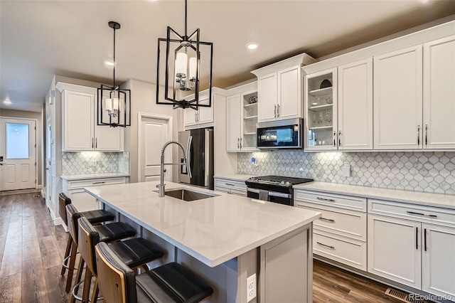 kitchen with appliances with stainless steel finishes, recessed lighting, a sink, decorative backsplash, and a breakfast bar area