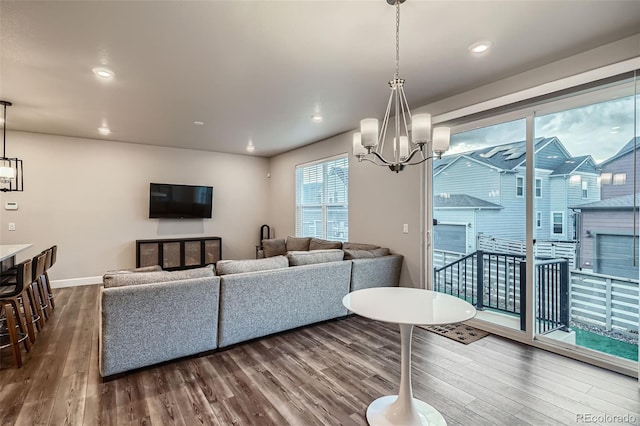 living area featuring a chandelier, dark wood finished floors, baseboards, and recessed lighting