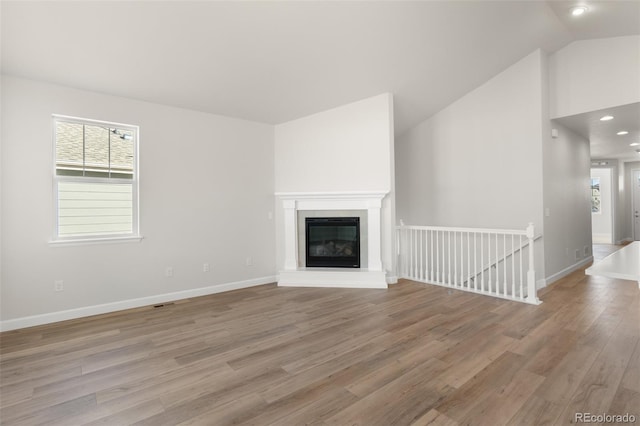 unfurnished living room with light hardwood / wood-style flooring and lofted ceiling