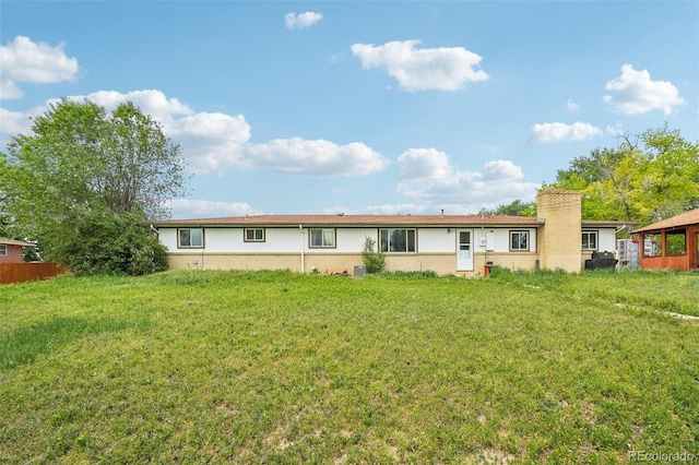 12734 Anhawa Ave, Longmont, CO 80503 - rear view of property featuring a lawn, stucco siding, and a chimney