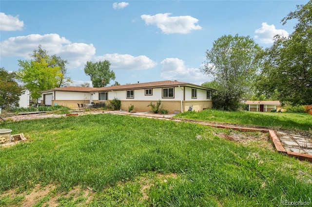 12734 Anhawa Ave, Longmont, CO 80503 - back of property with brick siding, a yard, and an attached garage
