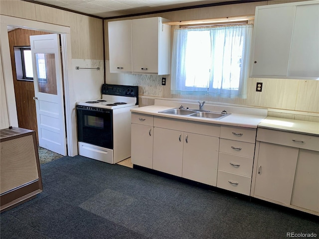 kitchen with electric range, white cabinets, light countertops, and a sink