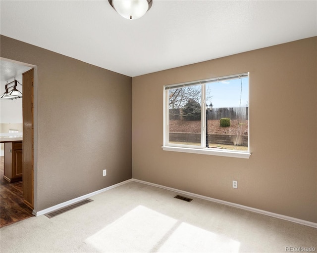 carpeted empty room with baseboards and visible vents