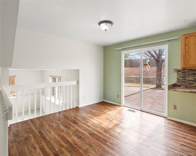 interior space featuring baseboards, visible vents, and wood finished floors
