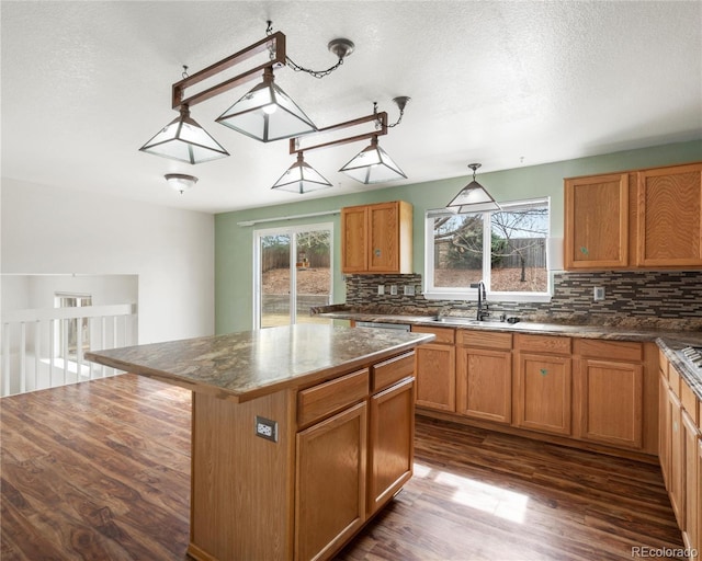 kitchen featuring a center island, a wealth of natural light, tasteful backsplash, and a sink