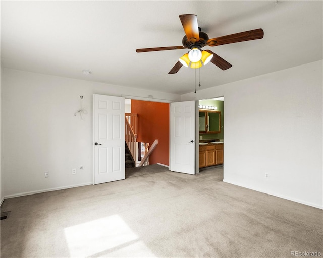 unfurnished bedroom with a ceiling fan, light carpet, ensuite bath, baseboards, and visible vents