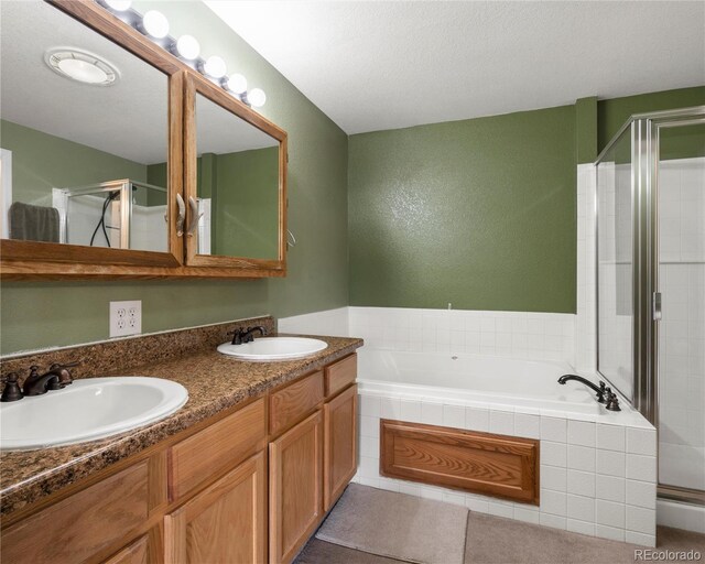 full bathroom featuring a sink, a garden tub, and a shower stall