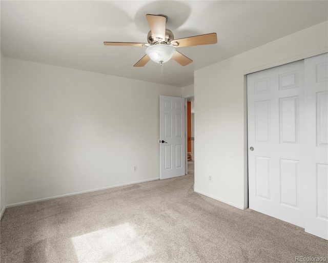 unfurnished bedroom with a closet, carpet floors, ceiling fan, and baseboards