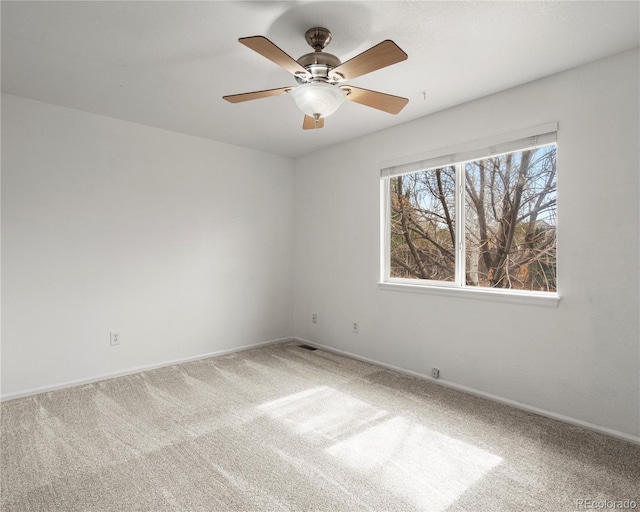 empty room featuring baseboards, carpet floors, and a ceiling fan