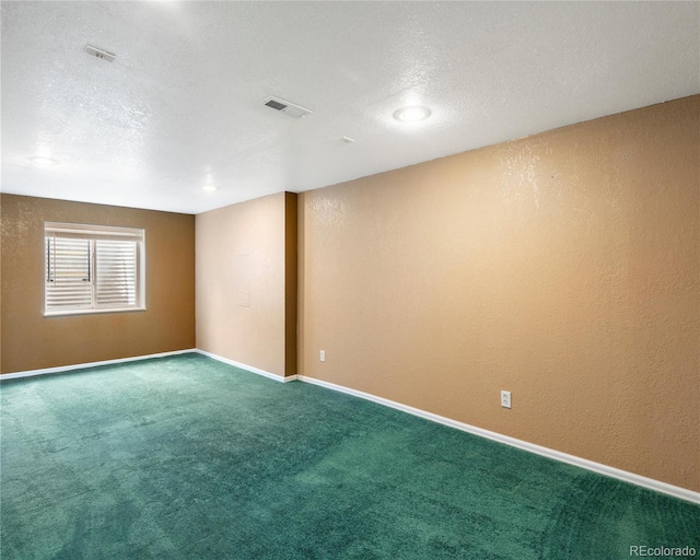 empty room with baseboards, visible vents, carpet, and a textured ceiling