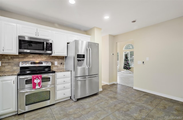 kitchen with stone counters, appliances with stainless steel finishes, tasteful backsplash, light tile patterned flooring, and white cabinetry