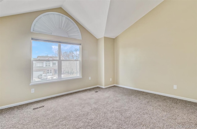 carpeted spare room with lofted ceiling