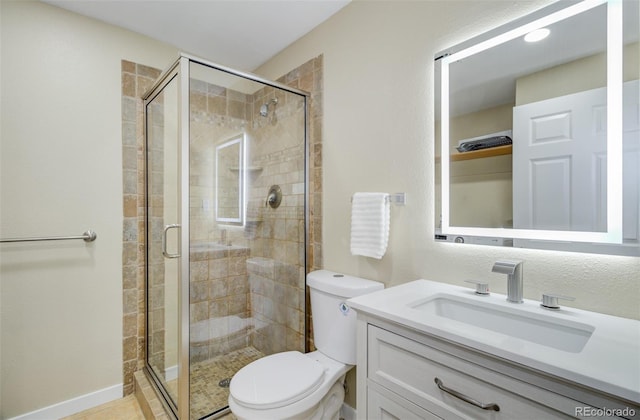 bathroom with tile patterned floors, vanity, an enclosed shower, and toilet