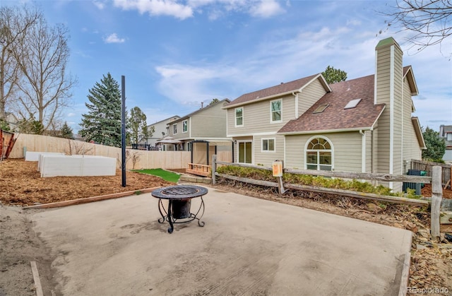 rear view of house with a fire pit and a patio area