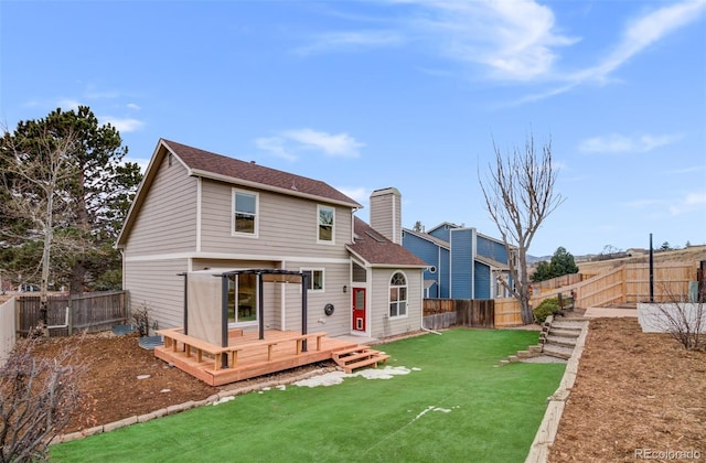 rear view of house with a lawn and a deck