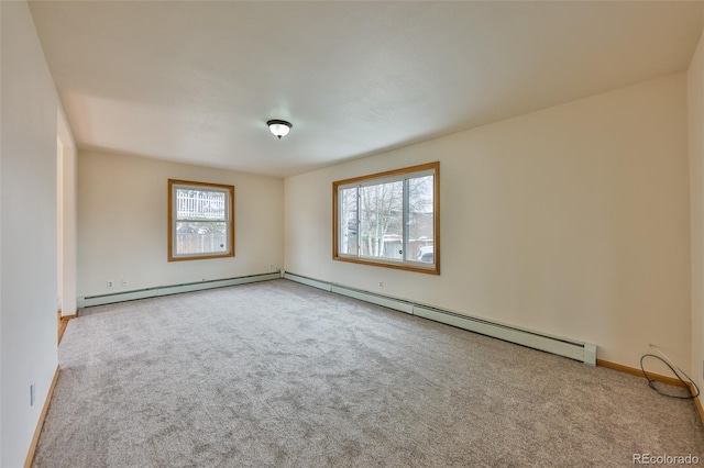 carpeted spare room featuring a baseboard heating unit