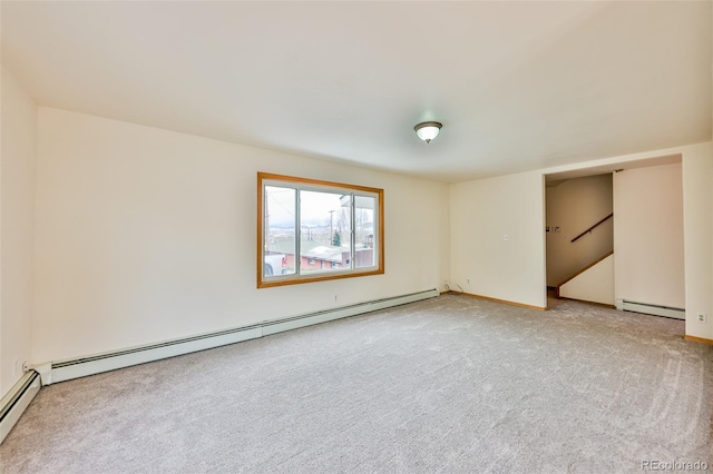 carpeted empty room with a baseboard heating unit