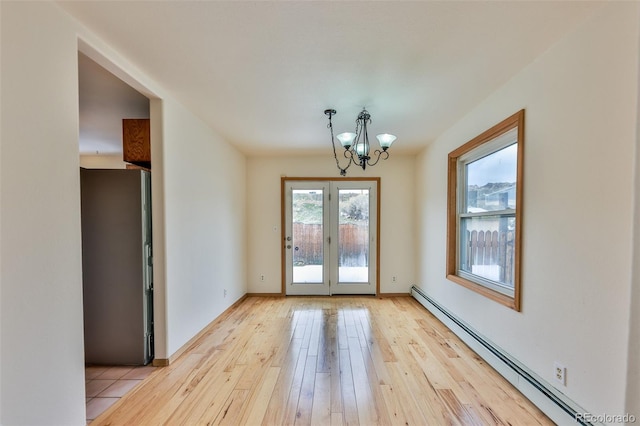 interior space with an inviting chandelier, a baseboard heating unit, french doors, and light hardwood / wood-style flooring