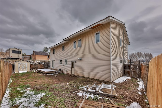 rear view of property featuring a storage unit