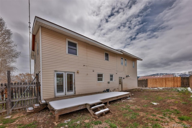 rear view of property featuring a wooden deck