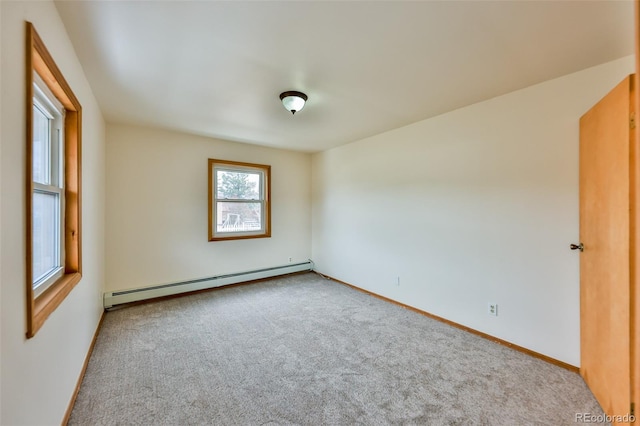 carpeted empty room featuring baseboard heating