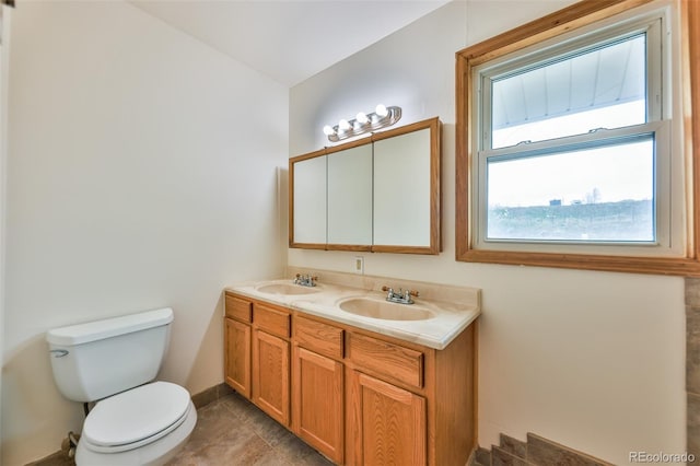 bathroom with dual bowl vanity, toilet, and tile floors