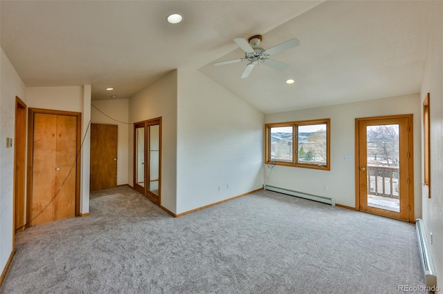 spare room with a baseboard radiator, carpet floors, ceiling fan, and vaulted ceiling