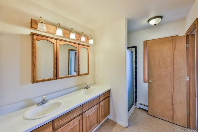 bathroom with a baseboard heating unit, tile flooring, double sink, vanity with extensive cabinet space, and a shower with door