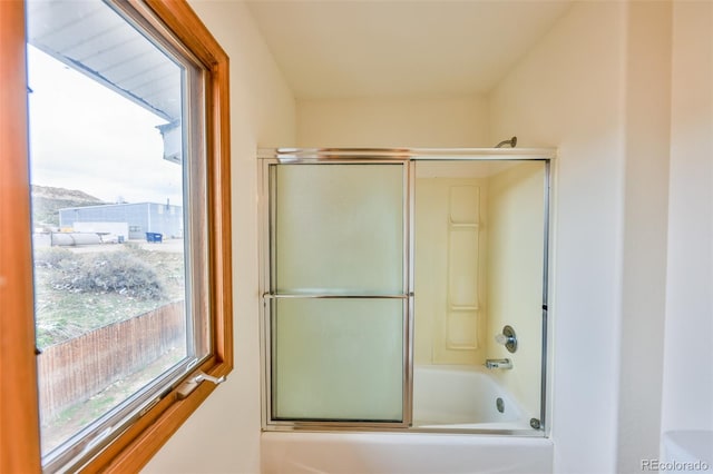 bathroom featuring bath / shower combo with glass door