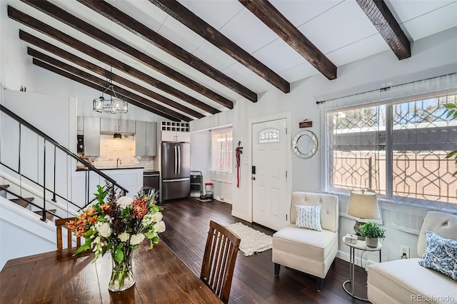 living room with beamed ceiling, a notable chandelier, dark wood-type flooring, and high vaulted ceiling