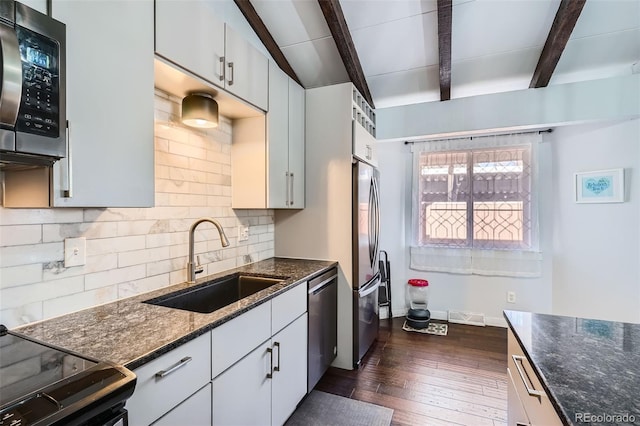 kitchen with beam ceiling, dark hardwood / wood-style flooring, sink, and stainless steel appliances