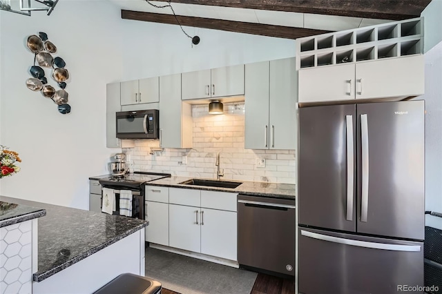 kitchen featuring vaulted ceiling with beams, decorative backsplash, dark stone countertops, and stainless steel appliances