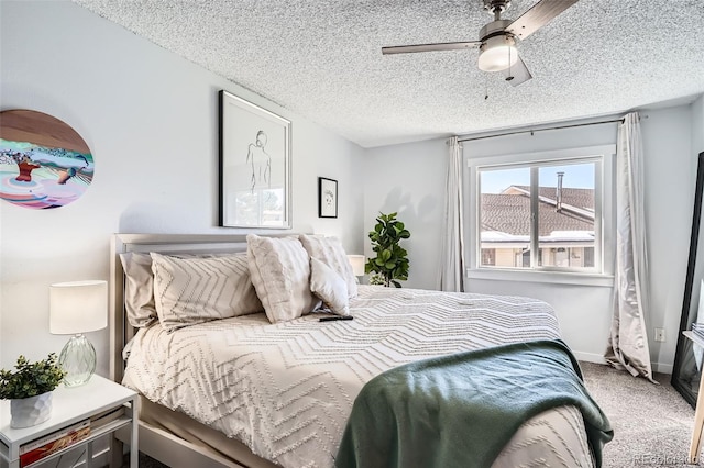 carpeted bedroom featuring ceiling fan and a textured ceiling