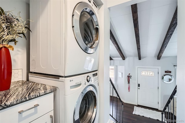 clothes washing area featuring dark hardwood / wood-style floors and stacked washer / dryer