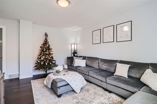 living room with a textured ceiling and dark hardwood / wood-style floors