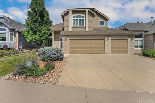 6836 Poppy Ct, Arvada, CO 80007 - view of front facade with driveway, brick siding, a garage, and a shingled roof