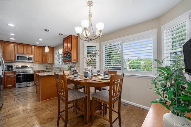 6836 Poppy Ct, Arvada, CO 80007 - dining room with a chandelier, wood finished floors, and recessed lighting