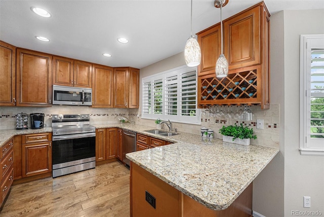 6836 Poppy Ct, Arvada, CO 80007 - kitchen featuring appliances with stainless steel finishes, brown cabinetry, light wood-style flooring, and recessed lighting