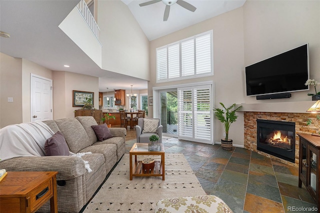 6836 Poppy Ct, Arvada, CO 80007 - living area with high vaulted ceiling, stone tile flooring, ceiling fan, and a stone fireplace