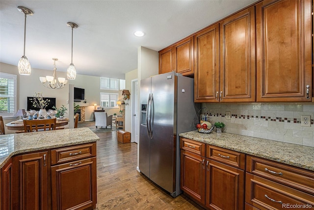 6836 Poppy Ct, Arvada, CO 80007 - kitchen with stainless steel refrigerator with ice dispenser, a chandelier, wood-type flooring, decorative backsplash, and decorative light fixtures